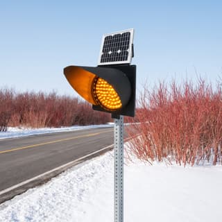 Illustration: a solar amber LED flashing beacon on a post beside a snowy country road.