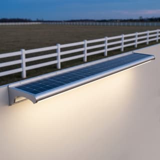 Illustration: a slim solar LED sign light bar washing a blank civic entrance board at dusk.