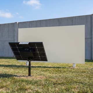 Illustration: a panel-on-post solar LED billboard uplight, switched off in daylight, in front of a blank monument sign.