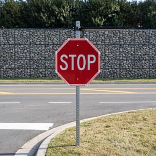 Illustration: a solar stop sign outlined by a lit red LED frame where a park maintenance drive meets a road.