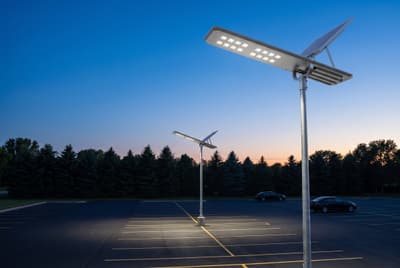Illustration: all-in-one solar LED parking-lot lights on poles lighting an empty lot at dusk.