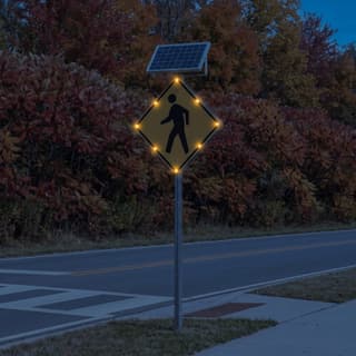Illustration: a solar flashing pedestrian crossing sign with eight LEDs glowing at a park path crossing after dark.
