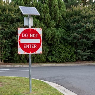 Illustration: a solar flashing do not enter sign at the one-way exit of a municipal parking lot.