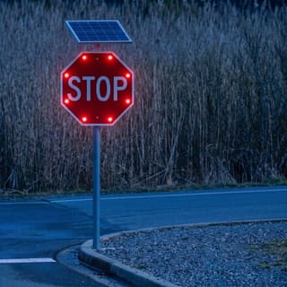 Illustration: a solar LED flashing stop sign glowing at the top of a boat ramp lane after dark.
