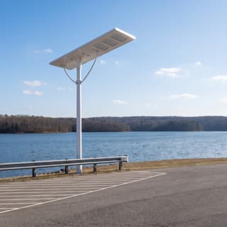 Illustration: a long slim white all-in-one solar LED lot light, switched off and charging, over a county boat-ramp parking lot in daylight.